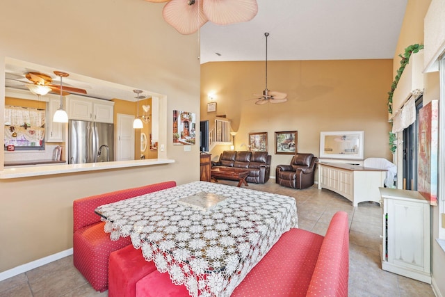 tiled dining room with ceiling fan and high vaulted ceiling