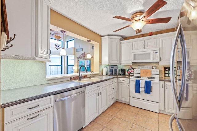 kitchen with stainless steel appliances, white cabinetry, ceiling fan, and sink