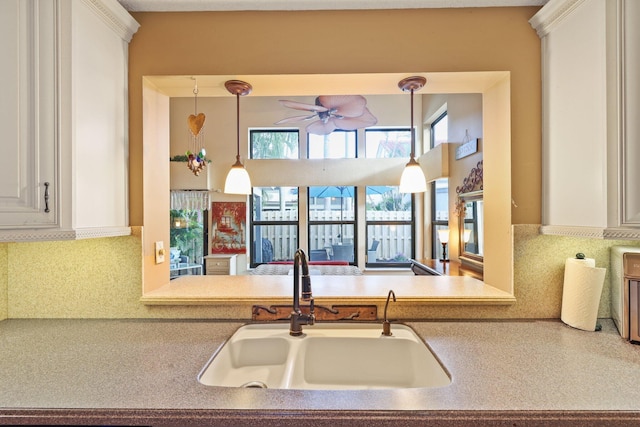 kitchen with decorative light fixtures, tasteful backsplash, ceiling fan, and sink