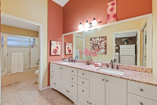 full bathroom with tile patterned flooring, vanity, toilet, and bath / shower combo with glass door