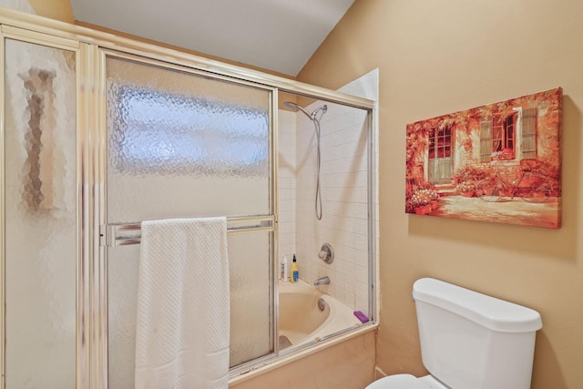 bathroom featuring bath / shower combo with glass door and toilet