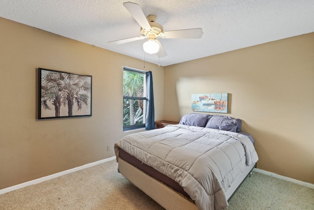 carpeted bedroom featuring ceiling fan and a textured ceiling