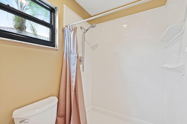 bathroom featuring a shower with shower curtain and toilet