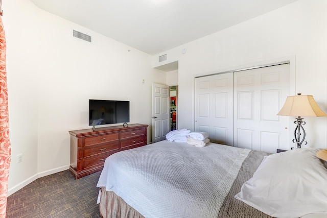 bedroom with dark colored carpet and a closet