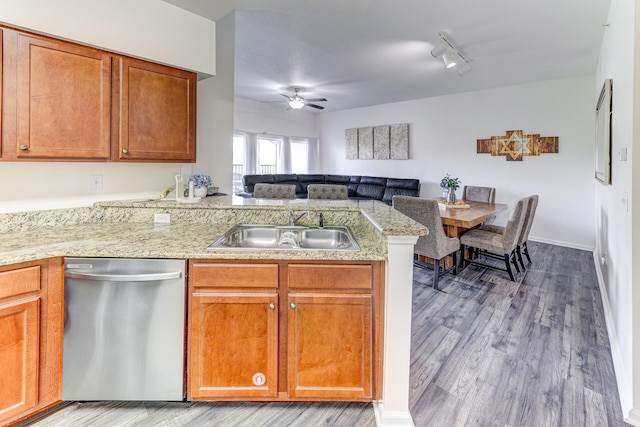 kitchen with stainless steel dishwasher, hardwood / wood-style flooring, ceiling fan, rail lighting, and sink