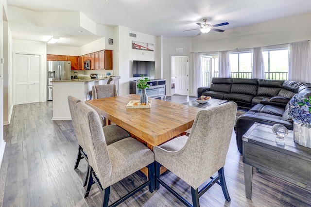 dining area with wood-type flooring and ceiling fan