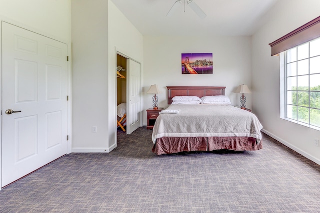 bedroom with dark carpet, ceiling fan, and a closet