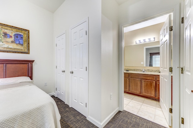 bedroom with light tile patterned flooring and ensuite bathroom