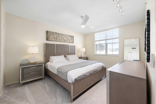 carpeted bedroom with a textured ceiling and ceiling fan