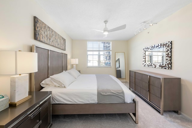 bedroom with light carpet, a textured ceiling, ceiling fan, and track lighting