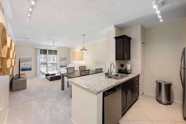 kitchen with ceiling fan, stainless steel appliances, track lighting, light colored carpet, and sink