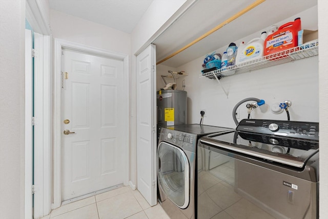 clothes washing area with laundry area, electric water heater, independent washer and dryer, and light tile patterned floors