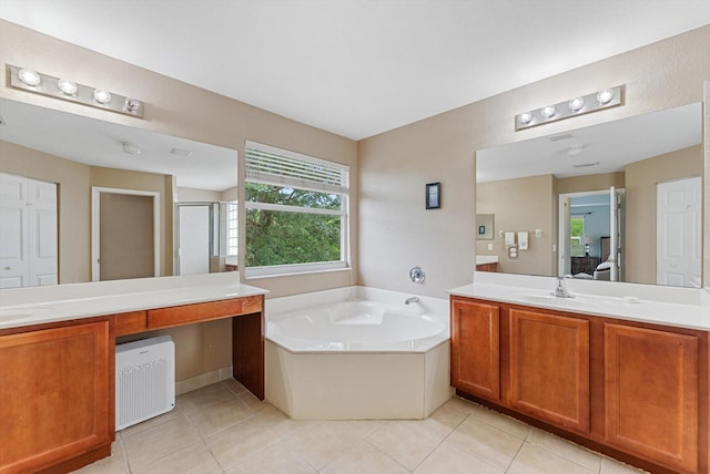 bathroom featuring vanity, a bath, and tile patterned floors