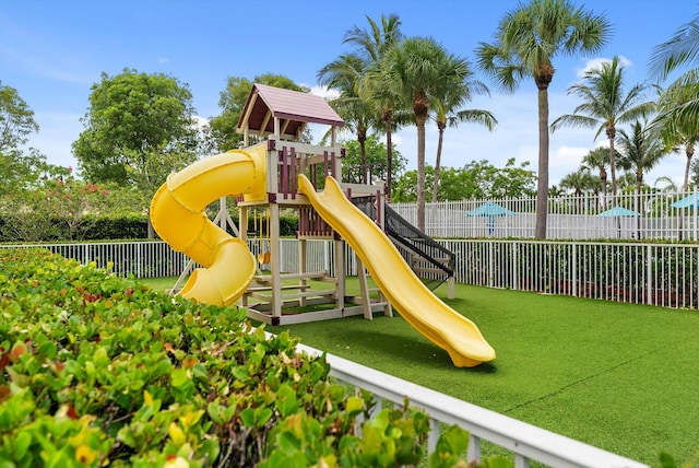 community play area featuring a lawn and fence