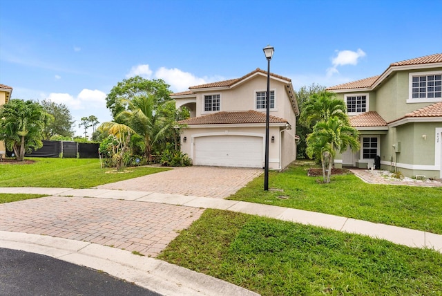 mediterranean / spanish house with a garage and a front lawn