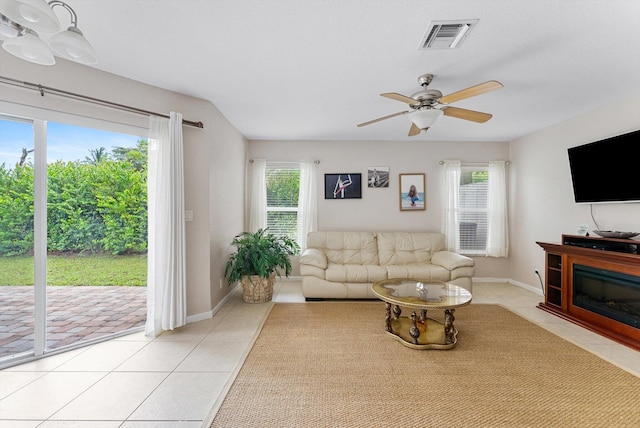 living room with light tile patterned floors, a wealth of natural light, and ceiling fan