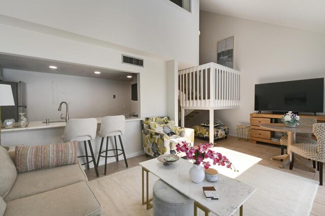 kitchen with backsplash, light stone counters, stainless steel appliances, sink, and white cabinets