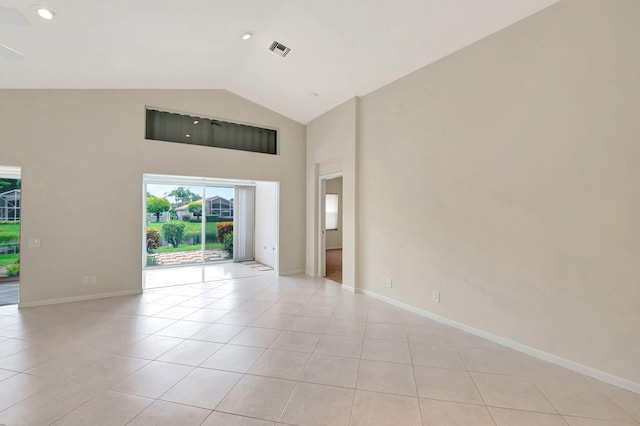 tiled spare room featuring vaulted ceiling