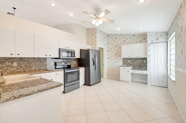 kitchen featuring tasteful backsplash, stainless steel appliances, ceiling fan, sink, and white cabinets