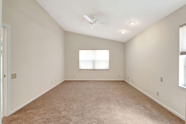 carpeted spare room featuring ceiling fan and vaulted ceiling