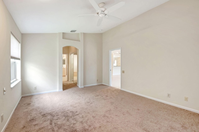 carpeted spare room featuring ceiling fan and lofted ceiling