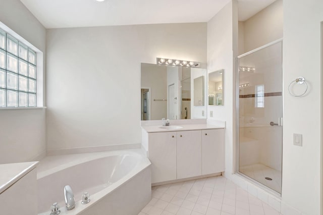 bathroom featuring plus walk in shower, vanity, and tile patterned floors