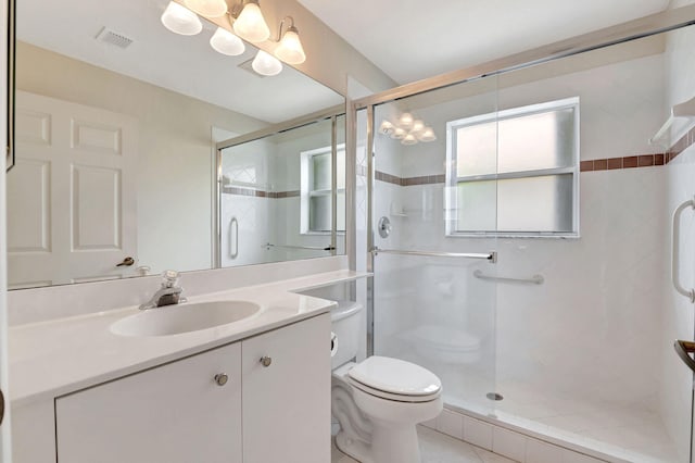 bathroom featuring vanity, toilet, and a shower with door