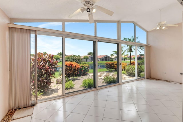 spare room with a wealth of natural light, light tile patterned floors, and vaulted ceiling