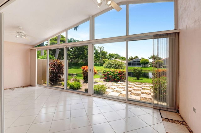 unfurnished sunroom featuring ceiling fan, a water view, and vaulted ceiling