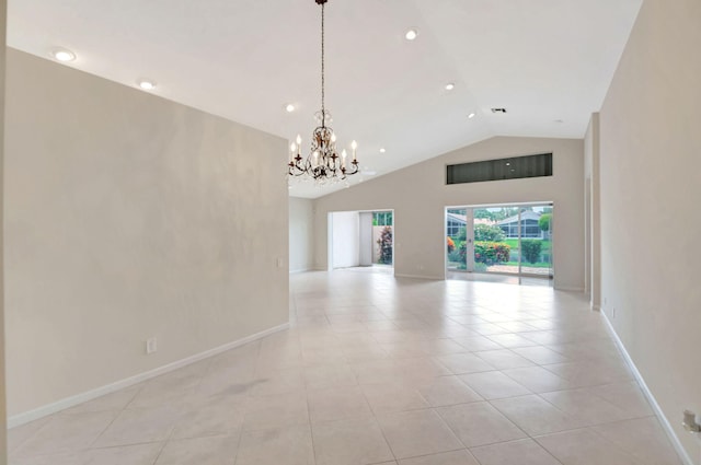 tiled spare room with high vaulted ceiling and an inviting chandelier