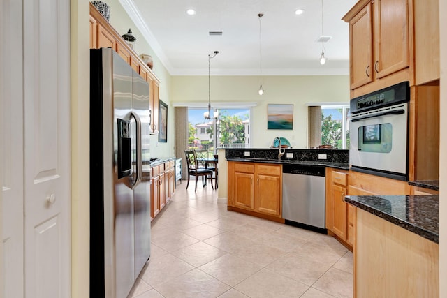 kitchen with appliances with stainless steel finishes, light tile patterned floors, pendant lighting, an inviting chandelier, and dark stone countertops