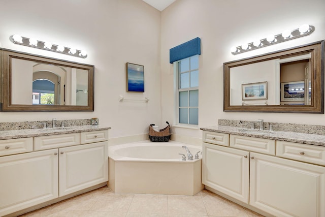 bathroom with a bath, vanity, and tile patterned floors