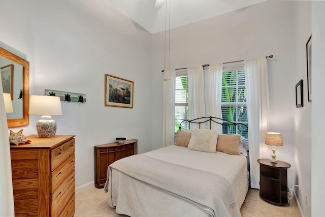 bedroom featuring ceiling fan, light tile patterned floors, and vaulted ceiling