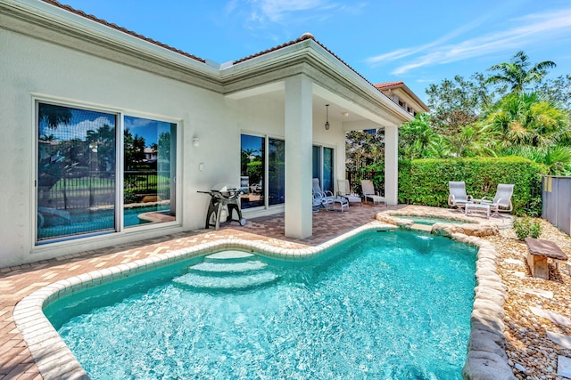 view of swimming pool featuring a grill and a patio