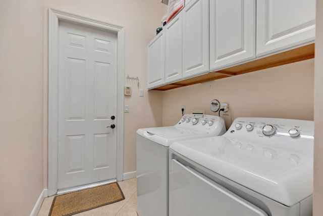 washroom with washer and clothes dryer, cabinets, and light tile patterned floors