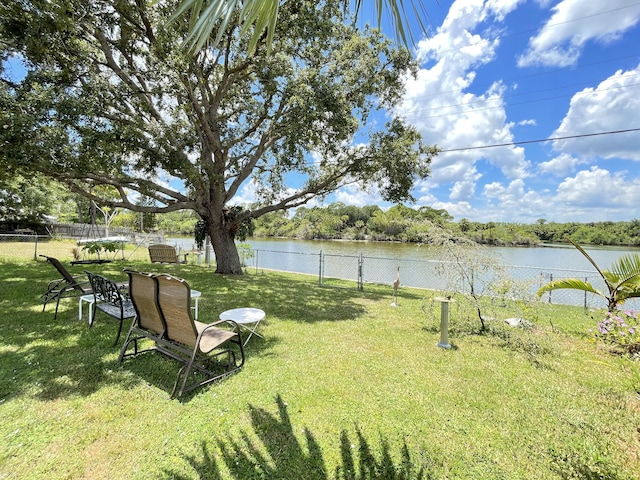 view of yard featuring a water view and fence