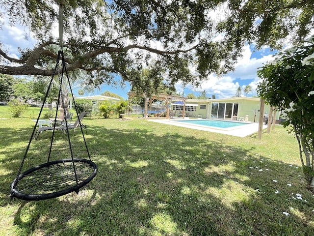 view of yard with a sunroom and an outdoor pool