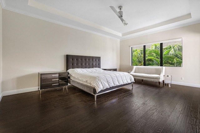 bedroom with a raised ceiling, ceiling fan, and dark wood-type flooring