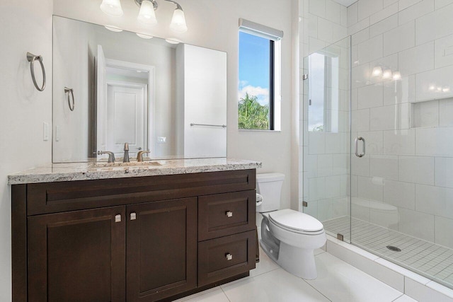 bathroom featuring toilet, vanity, walk in shower, and tile patterned flooring