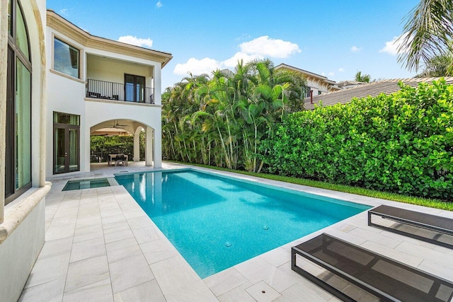 view of swimming pool with ceiling fan and a patio