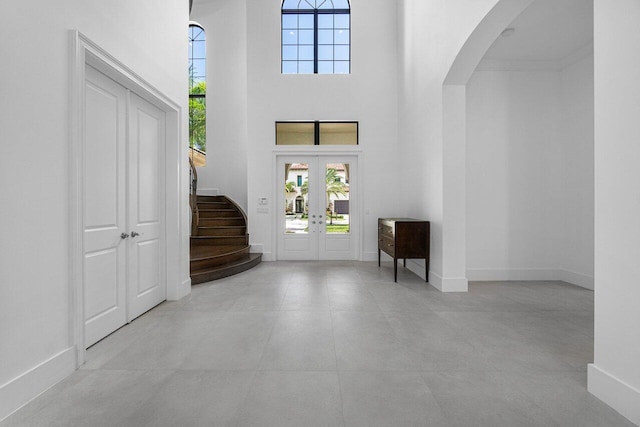 entrance foyer featuring a towering ceiling and french doors