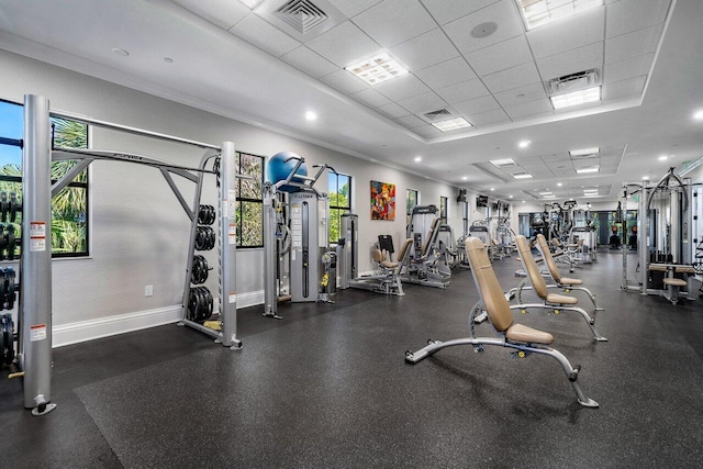 workout area with a paneled ceiling and ornamental molding