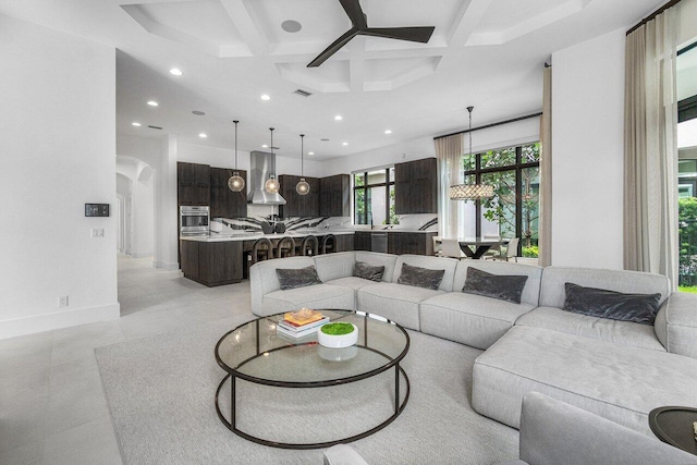 living room featuring ceiling fan, beam ceiling, and coffered ceiling