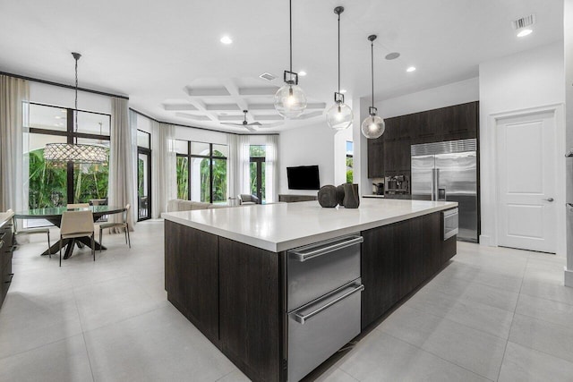 kitchen with ceiling fan, pendant lighting, coffered ceiling, stainless steel appliances, and a large island