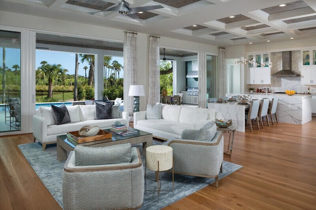 living room featuring coffered ceiling, ceiling fan, beam ceiling, and light hardwood / wood-style flooring