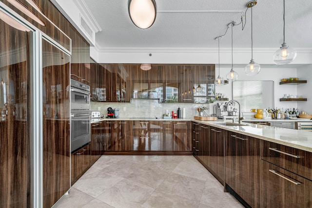 kitchen featuring dark brown cabinetry, light stone countertops, sink, cooktop, and a textured ceiling