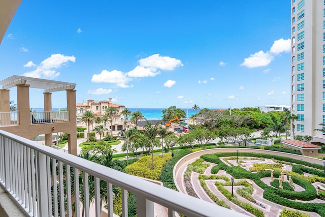 balcony with a water view and a pergola