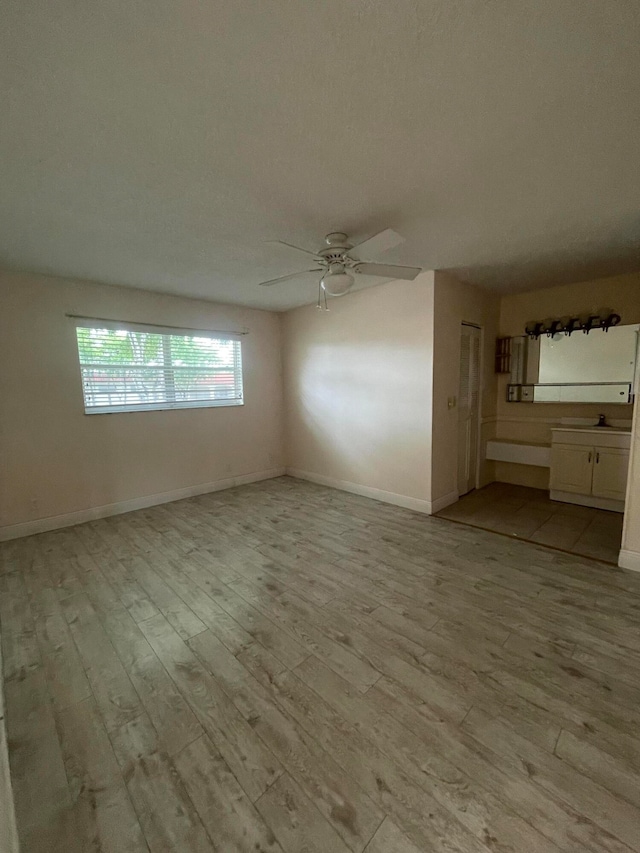 unfurnished living room featuring light hardwood / wood-style flooring and ceiling fan