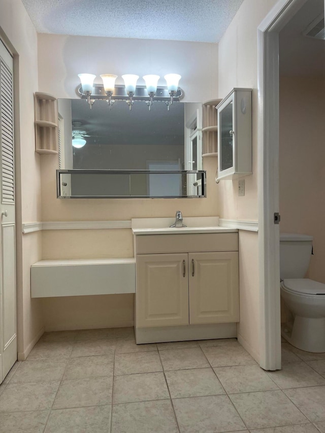 bathroom featuring toilet, tile patterned floors, and a textured ceiling