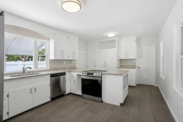 kitchen featuring white cabinetry, stainless steel appliances, sink, kitchen peninsula, and dark tile patterned flooring